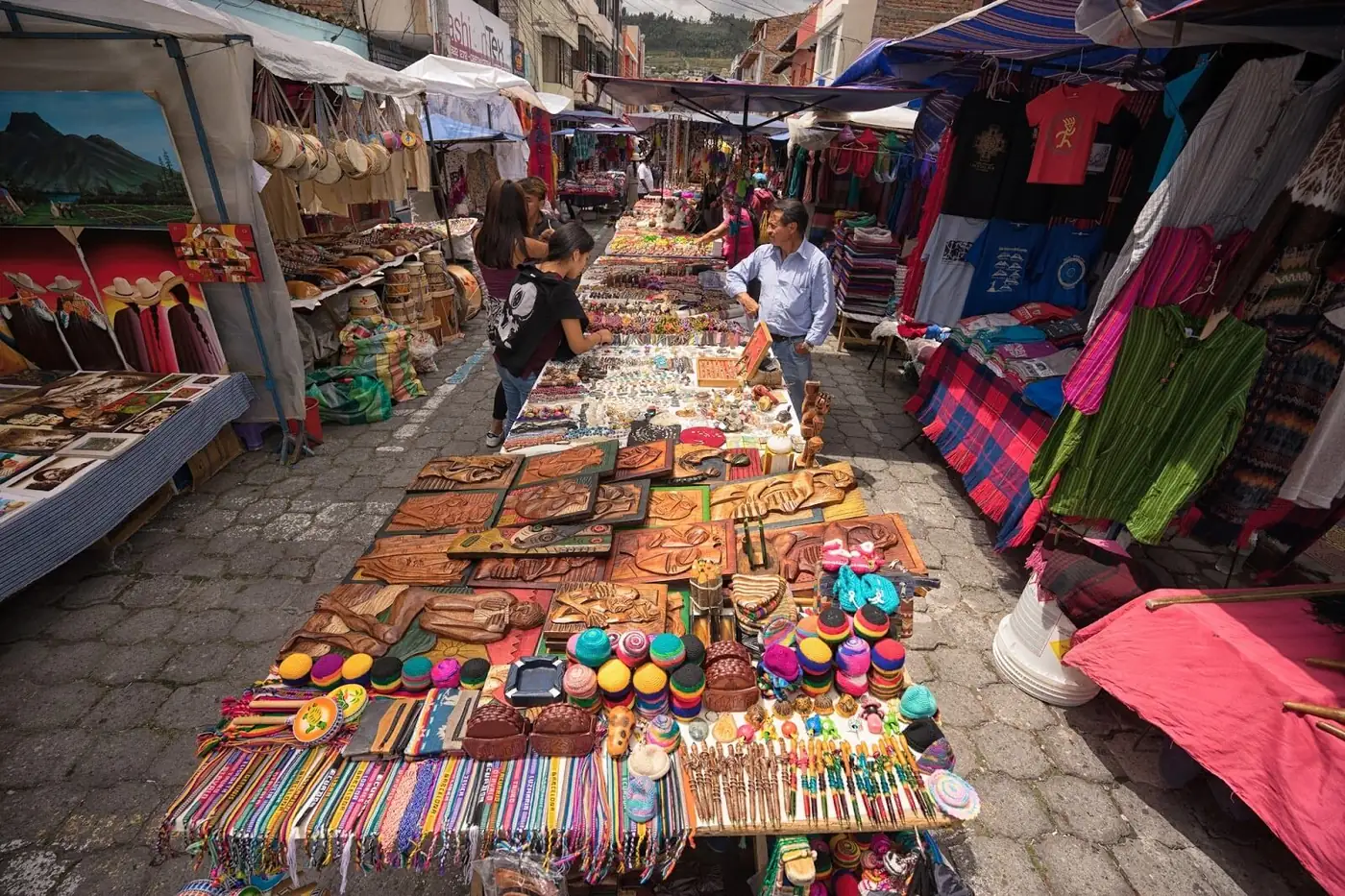 Stände mit Lederwaren, Armbändern und Textilien auf dem Markt von Otavalo